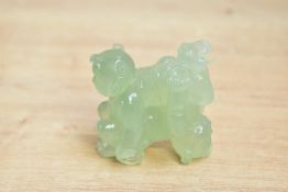 A 20th-century Chinese carved green-stone ornament, possibly jade, depicting two interlocking