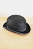 A Austin Reed of Regent Street bowler hat, in black with burgundy lining, measures approximately