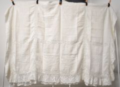 An antique Irish linen bed cover, in white cotton with a wide lace crochet border enclosing a grid