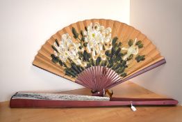 Two vintage Chinese oversized ornamental collapsible fans, hand painted with wood frames, the