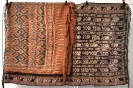 Two antique Indonesian Ikat Hinggi cloths in woven natural fiber, comprising a red, green and tan