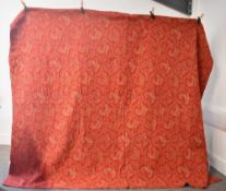 An antique handmade bedspread in vibrant red paisley, with pink, powder blue and pale sage green