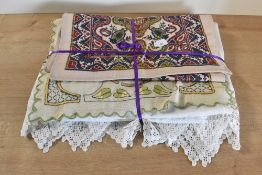 A collection of antique and vintage home linens, ton include a large white cotton tablecloth with