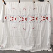 A vintage bedspread / throw in white cotton with blue and red floral embroidery, some flaws,