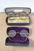 Two pairs of antique eye glasses or spectacles, round gold wire frames with local interest; their