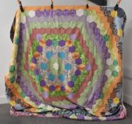 A 20th century vintage patchwork quilt in a honeycomb arrangement of cheerful, multicoloured fabrics