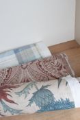 A bolt of iLiv Acanthium Autumn 100% cotton fabric, having a beige background with teal,