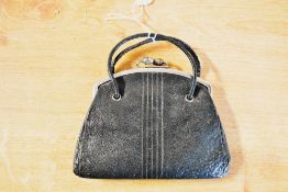 An antique children's handbag, in black leather with white metal frame, featuring acorn clasp