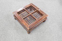 A Chinese low table, of square section form with spindled top over traditional design supports and