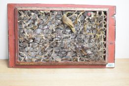 An antique Chinese carved temple panel, carved and reticulated with prunus and birds, the reverse