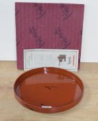 A modern Japanese lacquered tray, of circular form with gilt script to reverse, roughly