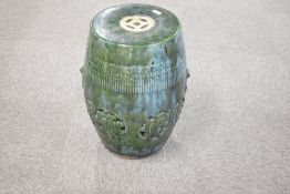 A Chinese mottled/dripped green glazed pottery garden seat, of typical barrel form with pierced
