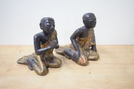 A near pair of Thai carved, painted and gilt decorated monk figures, modelled kneeling, one with