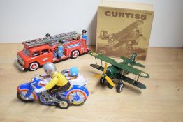 A Chinese made tin-plate wind-up bi-plane, with card packaging and key, sold along with a wind-up