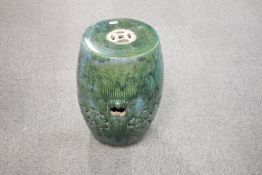 A Chinese mottled/dripped green glazed pottery garden seat, of typical barrel form with pierced
