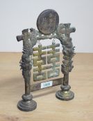 A Chinese moulded brass 'Double Happiness' symbol, the Chinese characters within dragon and