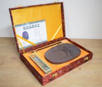 A 21st century Chinese Duan inkstone, of shaped oval form, decorated with Huaiji Hydropower Station,