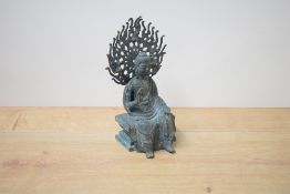 A reproduction Chinese cast and patinated metal figure of seated Buddha, cast in three pieces with