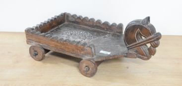 An interesting Chinese carved wooden child's pull-along cart, carved with horse head and three