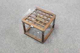 A Chinese glass and hardwood occasional table, having a glass top resting on 'woven' top with turned