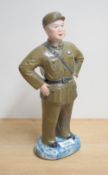 A Chinese cultural revolution glazed bisque porcelain figure of a soldier, standing proud with hands