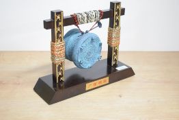 A 20th century table top reproduction of the Guanxi bronze drum, the drum suspended by cord from a