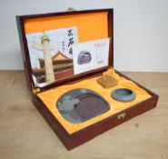 A modern Chinese Qingqu inkstone, carved from Songhua stone and sold along with a water bowl and