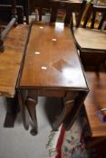 A mid 20th Century drop leaf dining table and an early 20th Century rail back dining chair