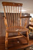 A 19th Century dark stained Windsor carver chair having spindle back and turned frame with H