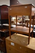 A traditional stained frame sewing table having lift lid with compartmental interior and undershelf,