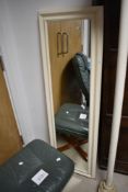 A painted full length wall mirror