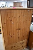 A modern pine child's wardrobe having double drawer to base, dimensions approx. H140 W80 D50cm