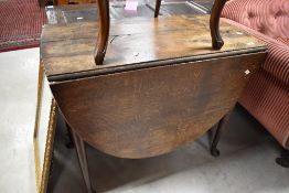A 19th Century oak dining table having drop leaf and cabriole legs, width approx. 89cm