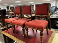 A set of three Victorian oak dining chairs having overstuffed seats and backs