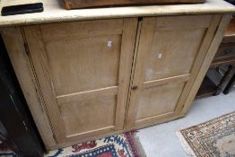 A stripped pine cabinet, dimensions approx. W116 H93 D54cm