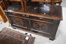 A traditional oak kist having double carved panels, width approx. 122cm