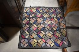 A vintage pegged style rug, having circular pattern, approx. 104 x 102cm