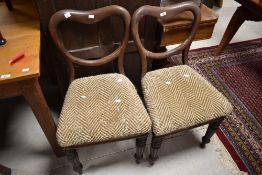 A pair of Victorian mahogany balloon back dining chairs having overstuffed seats