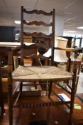 A 19th Century ladder back carver chair having rush seat