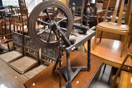 A traditional spinning wheel , dark stained