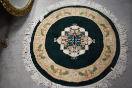 A modern Chinese rug of circular form having green ground with cream border, diameter approx. 94cm
