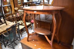 An early 20th Century mahogany occasional table having oval top and undertier, width approx. 75cm
