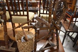 A traditional oak spinning wheel and assorted spinners utensils