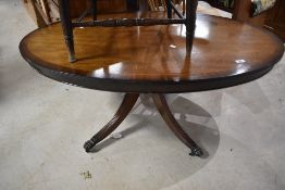 A reproduction Regency style coffee table having oval top , on quadruple fluted legs and claw