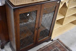 A vintage oak effect bookcase having leaded effect to glazed doors, width approx. 84cm