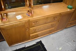 A modern Ercol sideboard having central three drawers, flanked by cupboards, width approx. 155cm