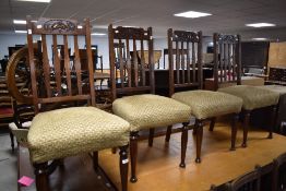 A set of four early 20th Century mahogany rail back dining chairs having Art Nouveau style carved
