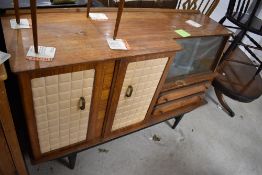 A vintage lounge unit having double cupboard with quilted vinyl doors , and glazed display section