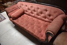 A 19th Century mahogany frame roll end settee in the classical style, having cerise buttoned