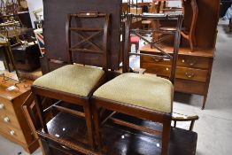 A pair of 19th Century Regency style dining chairs having overstuffed drop in seats